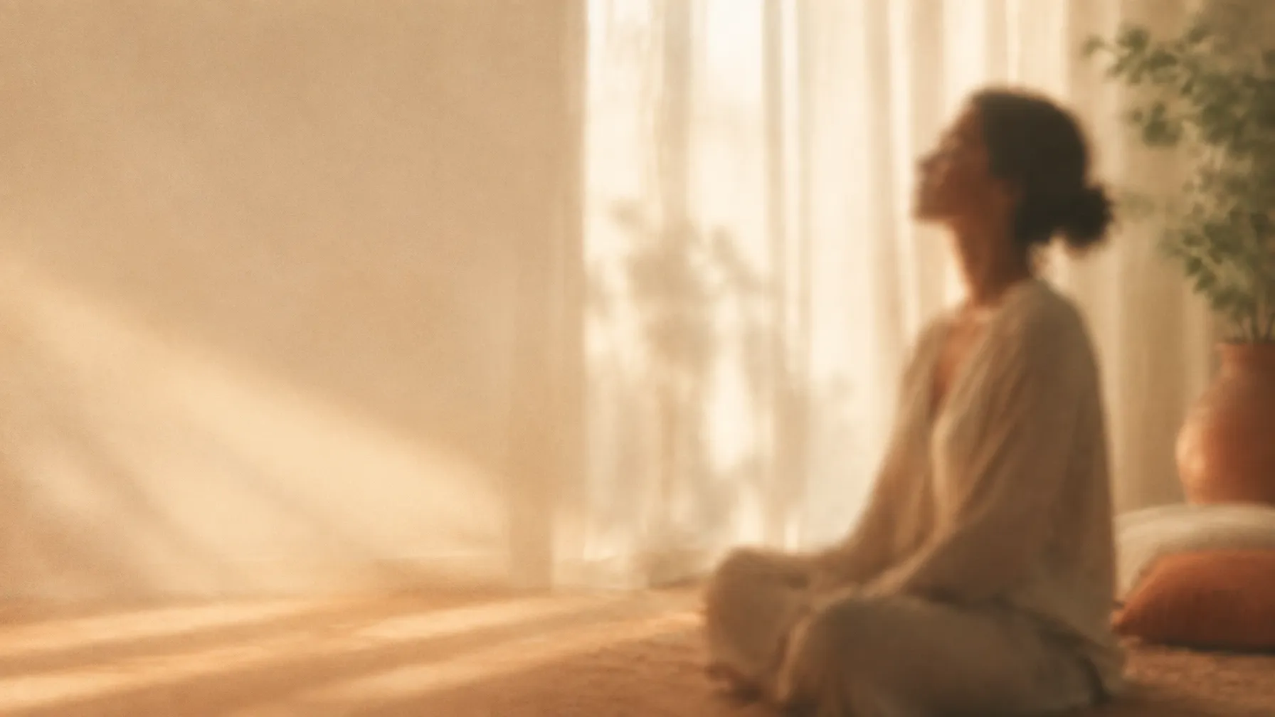 A woman sitting in quiet morning light beside a window